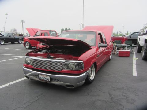 1964 Ford Ranchero - A red Ford Ranger pickup truck is displayed with its hood open at an outdoor event.