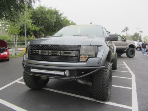 1964 Ford Ranchero - A gray Ford F-150 Raptor pickup truck is parked in a lot, a prominent aftermarket bumper and light bar.