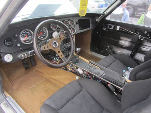1964 Ford Ranchero - The interior of a vehicle shows a dashboard filled with numerous gauges and a sporty steering wheel, suggesting a custom build.