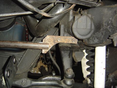 1986 Ford Bronco - Underside view of a vehicle's steering box bracket and suspension components.