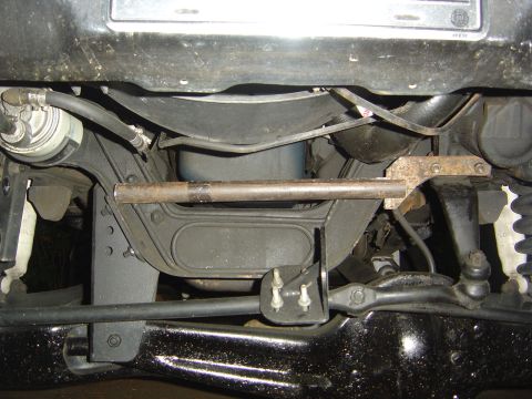 1986 Ford Bronco - Close-up of the steering box bracket and related undercarriage parts on a vehicle.