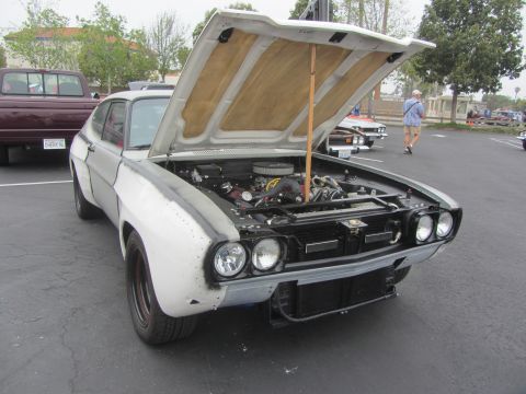 1964 Ford Ranchero - Ford Capri with hood open, engine exposed. Front end is in primer. Another vehicle is parked behind.