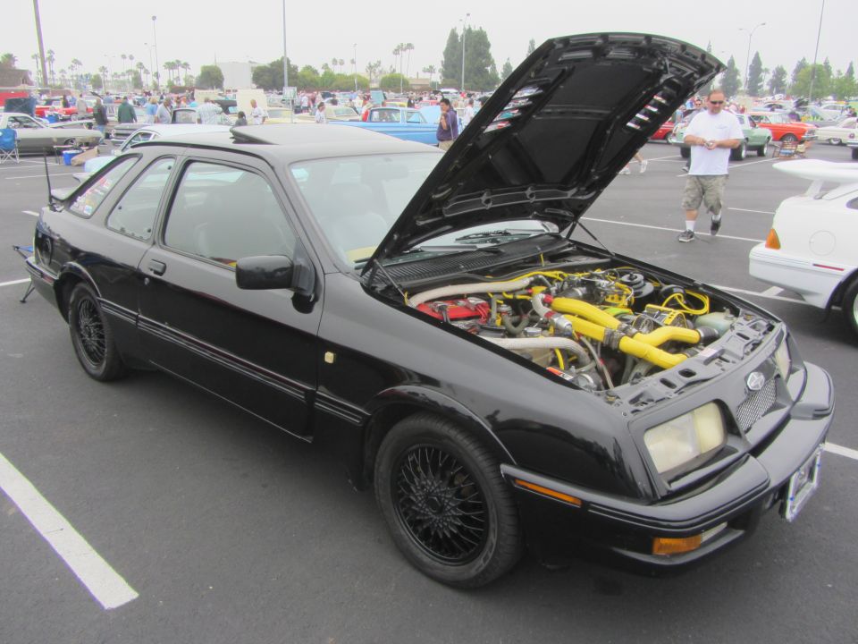 Black Ford Sierra XR4Ti with engine exposed, parked at a car show