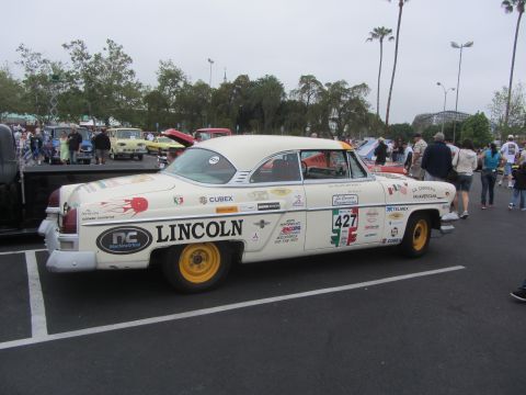 1964 Ford Ranchero - A white Lincoln sedan, adorned with numerous racing stickers and the number 427, is parked in a lot.