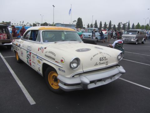 1964 Ford Ranchero - A vintage Mercury Monterey, decorated with numerous racing stickers, sits in a parking lot.
