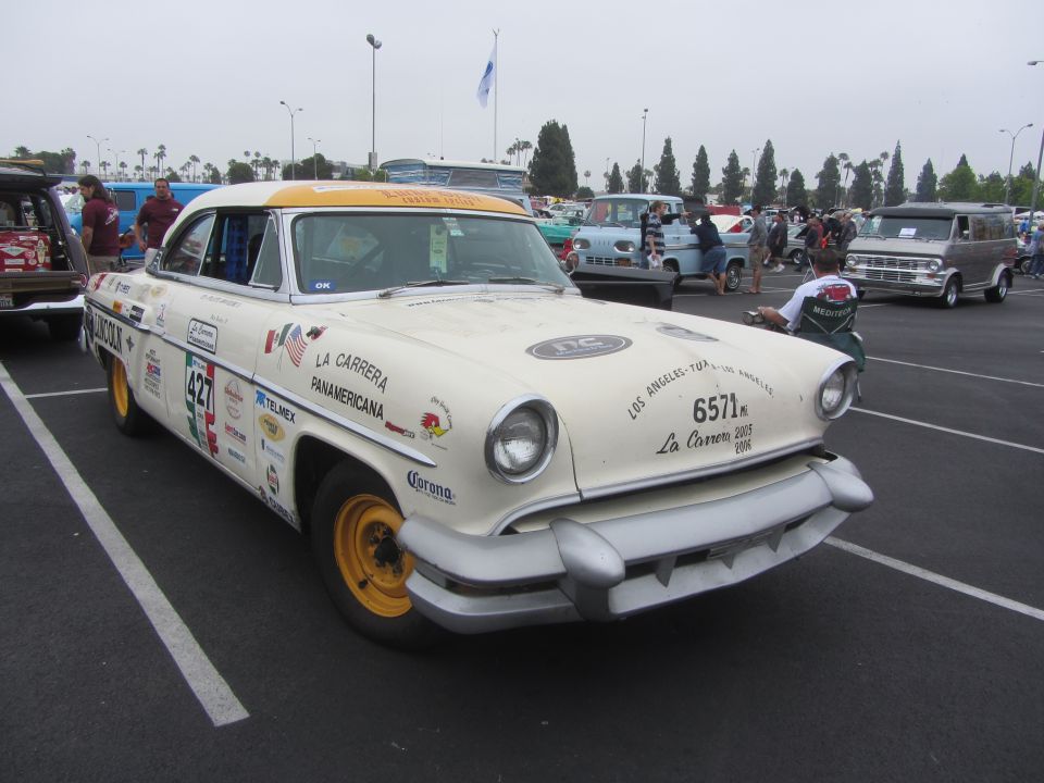1955 Mercury Monterey with racing decals and yellow wheels parked in a lot