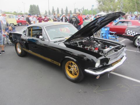 1964 Ford Ranchero - A black 1966 Ford Mustang Shelby GT350 is displayed with its hood open, gold racing stripes and wheels.