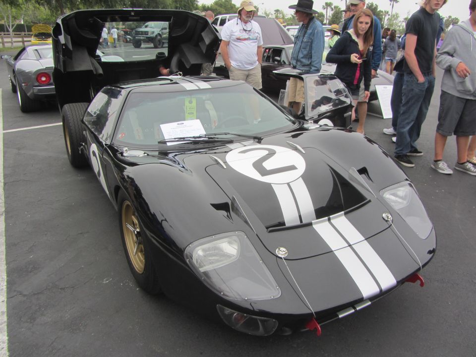 Black Ford GT40 with white racing stripes and the number 2 on the hood. Doors are open, people are looking at it