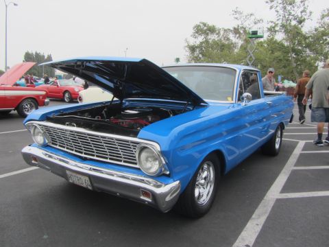 1964 Ford Ranchero - A blue 1964 Ford Ranchero is parked with its hood open, revealing the engine bay.