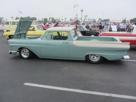 1964 Ford Ranchero - A light blue and cream 1957 Ford Ranchero is parked at an outdoor car show with other vehicles around.