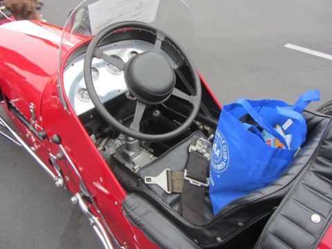 1964 Ford Ranchero - Interior view of a vintage race car, showing the steering wheel, gauges, and a seatbelt.