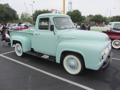 1964 Ford Ranchero - A light blue 1953 Ford F-100 pickup truck is parked in a lot with other vehicles visible.