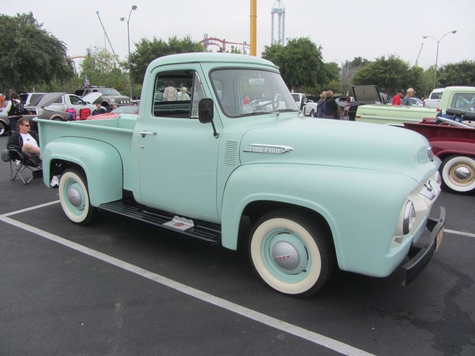 Light blue 1953 Ford F-100 pickup truck parked, front 3/4 view, white wall tires, chrome bumper