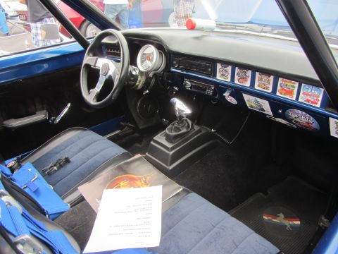 1964 Ford Ranchero - Interior view of a modified car, racing seats, a roll cage, and various stickers on the dash.