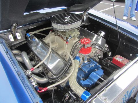 1964 Ford Ranchero - The engine bay of a blue vehicle showcases a powerful V8 engine with custom modifications and performance parts.
