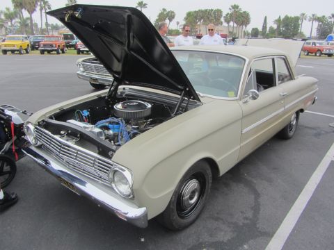 1964 Ford Ranchero - A beige 1964 Ford Falcon sedan is displayed with its hood open, revealing the engine compartment.