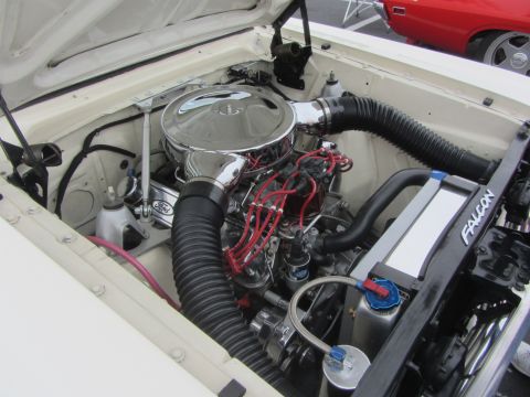 1964 Ford Ranchero - The engine compartment of a classic Ford Falcon is detailed with a chrome air cleaner and visible spark plug wires.