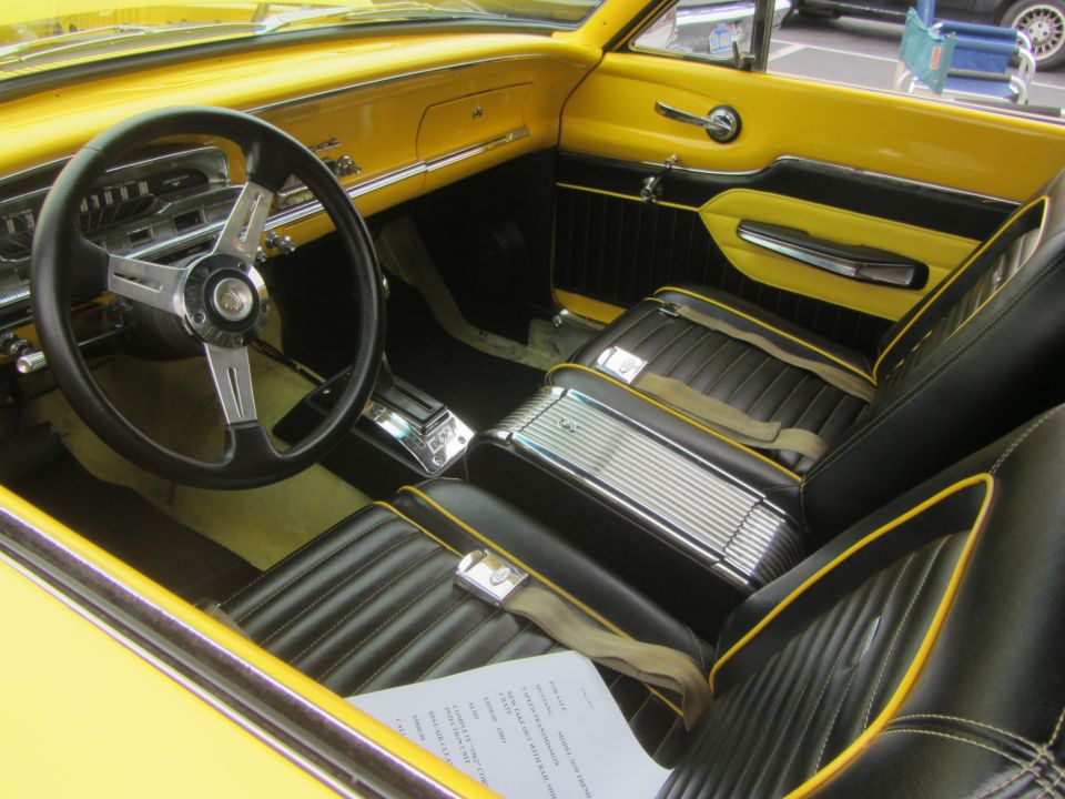 Interior of a 1964 Ford Ranchero with yellow dashboard and black seats