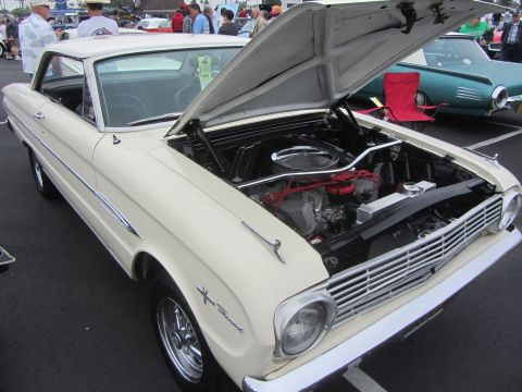 1964 Ford Ranchero - A cream-colored 1964 Ford Ranchero is displayed with its hood open, revealing the engine compartment.