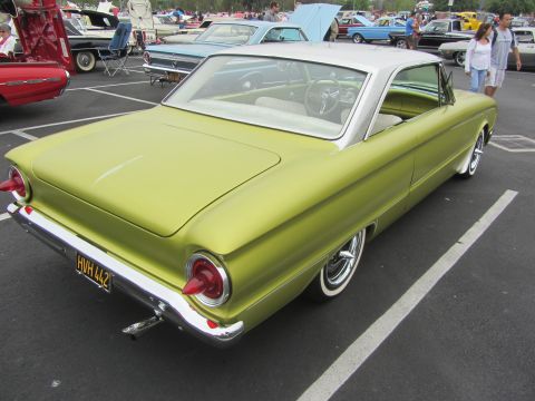 1964 Ford Ranchero - A lime green 1961 Ford Falcon is parked in a lot, showing its rear end and distinctive tail lights.
