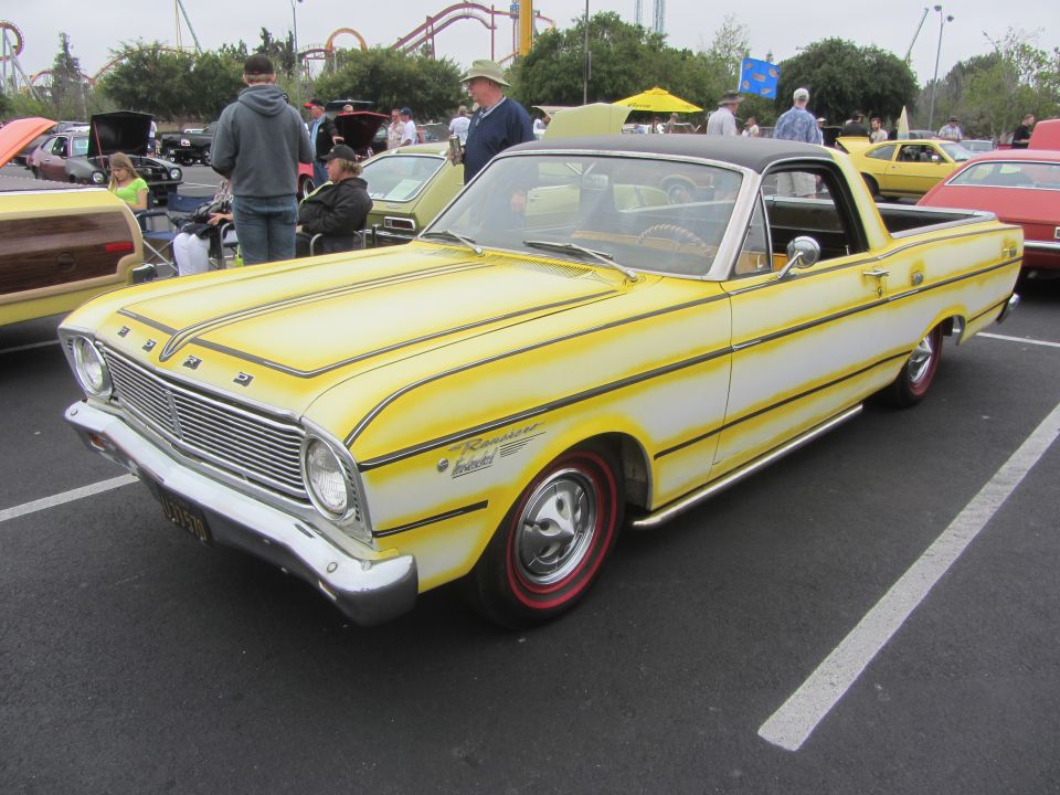 Yellow and white 1964 Ford Ranchero with black pinstriping, chrome side pipes, and red-rimmed wheels