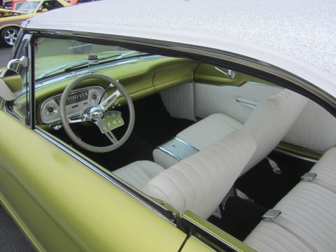 1964 Ford Ranchero - The interior of a classic car features white seats and a distinctive dashboard with a large steering wheel.