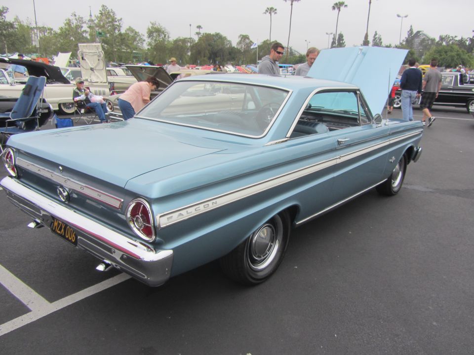 Blue 1964 Ford Falcon coupe with chrome trim and white side stripes, parked outdoors