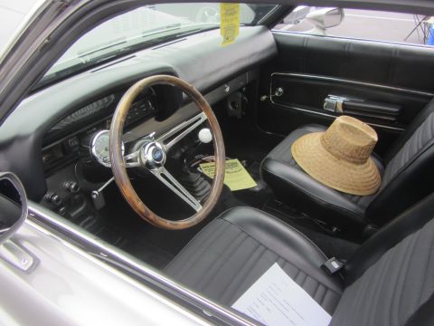 1964 Ford Ranchero - The interior of a 1964 Ford Ranchero features a wooden steering wheel and a straw hat resting on the passenger seat.