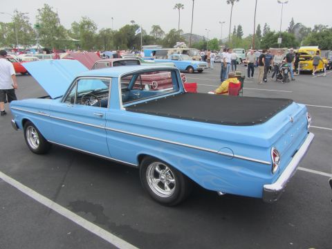 1964 Ford Ranchero - A light blue 1964 Ford Ranchero pickup truck is parked at an outdoor event, a black tonneau cover over its bed.