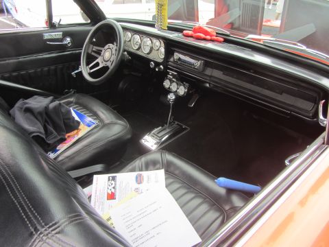 1964 Ford Ranchero - The interior of a classic car features a dashboard with multiple gauges and a floor-mounted shifter.