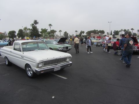 1964 Ford Ranchero - A white 1963 Ford Falcon Ranchero is displayed at an outdoor car show with several other vehicles and attendees.