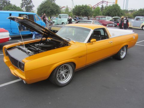 1964 Ford Ranchero - A yellow ranchero with its hood open, revealing the engine, parked at an outdoor event.