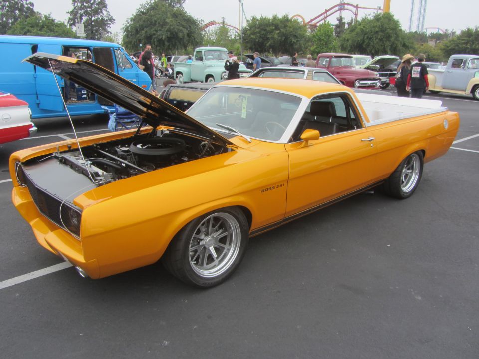 Yellow 1970s ranchero with hood open, showing engine