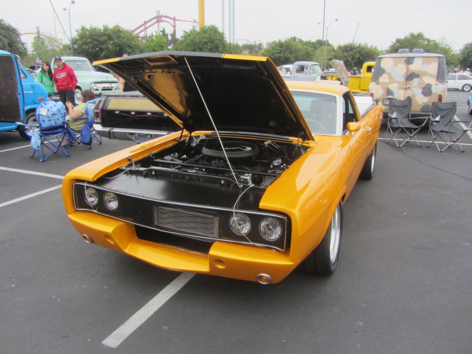 1970 Dodge Charger with hood open, showing engine. Other vehicles and people in background