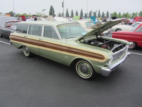 1964 Ford Ranchero - A 1964 Ford Falcon Squire wagon with its hood open at a car show, parked next to other vehicles.