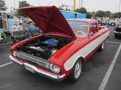 1964 Ford Ranchero - A red and white 1964 Ford Ranchero is parked with its hood open, revealing the engine bay.