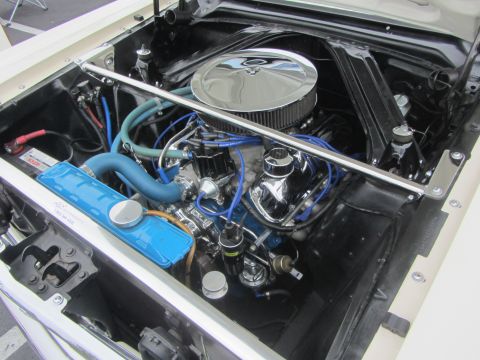 1964 Ford Ranchero - The engine bay of a 1964 Ford Ranchero, a chrome air cleaner and blue hoses.