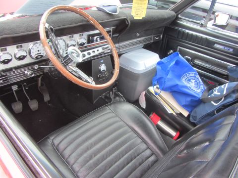 1964 Ford Ranchero - The interior of a classic car features a wooden steering wheel and a dashboard with multiple gauges and a radio.