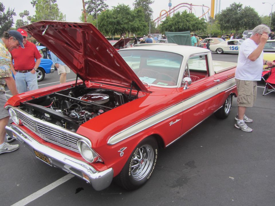 Red and white 1964 Ford Ranchero with hood open, showing engine