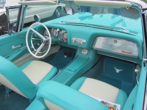 1964 Ford Ranchero - The interior of a turquoise and cream 1958 Ford Thunderbird convertible is visible, with another classic car in the background.