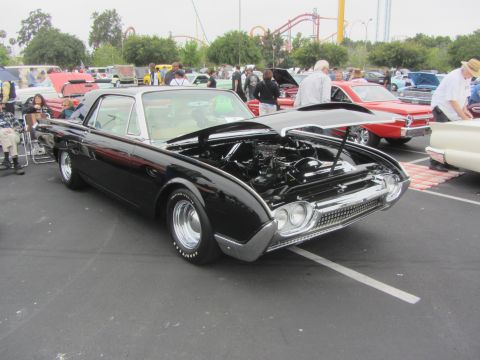 1964 Ford Ranchero - A black 1961 Ford Thunderbird is displayed with its hood open at an outdoor car show.