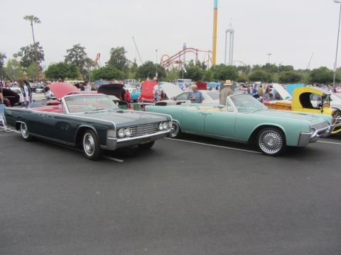 1964 Ford Ranchero - Two classic Lincoln Continental convertibles, a dark green and a teal model, are displayed at an outdoor car show.