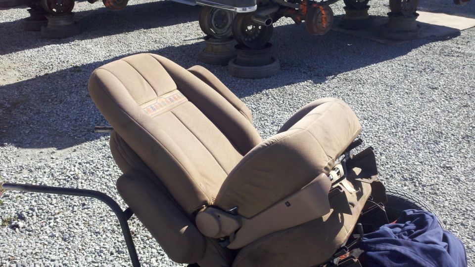 Tan car seat with "BRONCO" embossed on headrest, angled view