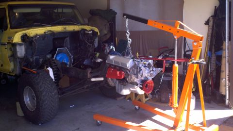1978 Ford Bronco - Engine hoist lifting the engine out of a 1978 Ford Bronco during a motor rebuild.