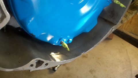 1978 Ford Bronco - A blue painted automotive part with a fitting covered in yellow tape is shown inside a metal casing.