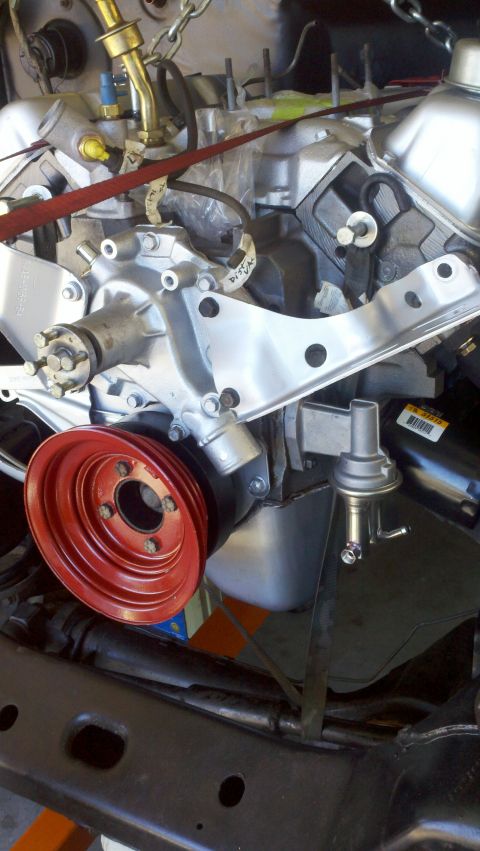 1978 Ford Bronco - Engine components during a motor rebuild, showing a red pulley and fuel pump.