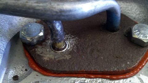 1978 Ford Bronco - Close-up of an engine component with a gasket and bolts, the Supermotors.net watermark.