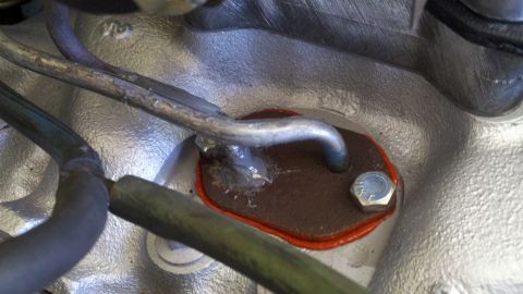 1978 Ford Bronco - Close-up of an engine part, showing a gasket and metal tubing.
