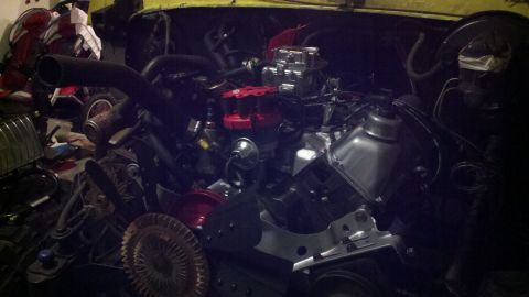 1978 Ford Bronco - The engine bay shows a V8 engine with a carburetor and distributor, possibly undergoing a rebuild.