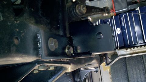 1995 Ford Bronco - Detail shot of vehicle undercarriage components, including a black metal bracket and fasteners.